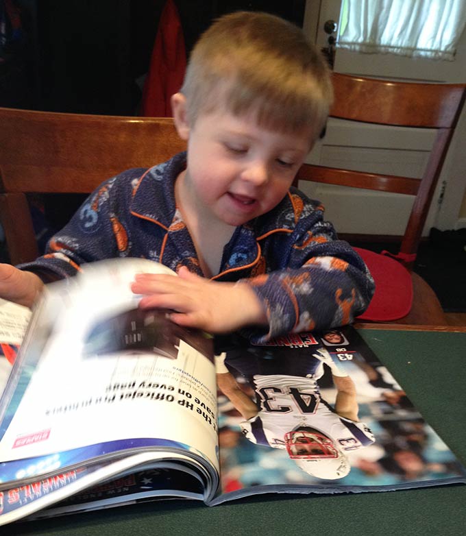 Biggest Little Fan. Hudson loves a good football game, the Pats in particular. Then we noticed him with the old 2010 New England Patriots yearbook.