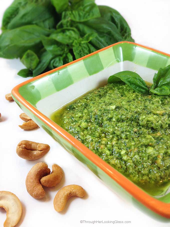 this easy cashew basil pesto in a serving bowl with roasted cashews in the foreground