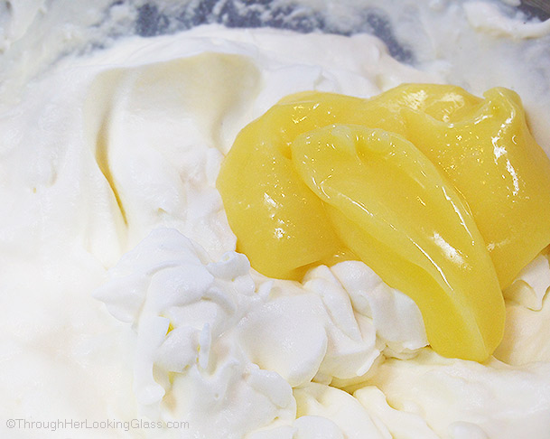 a close up of whipped cream and lemon curd in a bowl