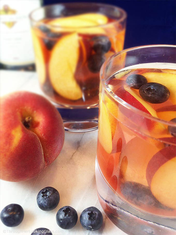 Easy and fruity: Make White Wine Peach Sangria by the pitcherful! Sweet peaches macerate in a delicious cocktail for all the pool & patio summer parties!