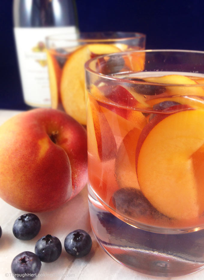 Easy and fruity: Make White Wine Peach Sangria by the pitcherful! Sweet peaches macerate in a delicious cocktail for all the pool & patio summer parties!