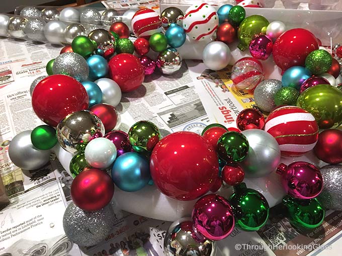 This Willy Wonka Christmas Ball Wreath is a fun and sparkly way to welcome in the Christmas holidays. Easy to make too. Just hot glue Christmas ornaments of various colors, shapes and sizes onto a styrofoam wreath form.